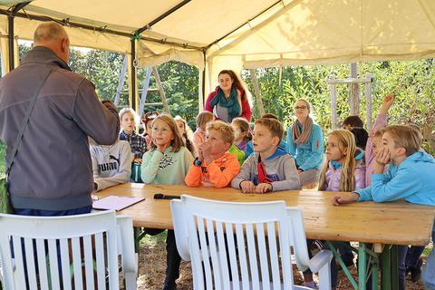 Schüler der Schwarzbachschule besuchten im Rahmen der Aktion „Lesen an besonderen Orten“ den Vereinsgarten des Obst- und Gartenbauvereins. Foto: Susanne Rapp