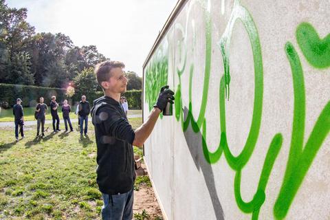 Lars Lorenz gestaltet die neue Graffitiwand an der Freizeitfläche in der Berzallee. Foto: Dziemballa (VF