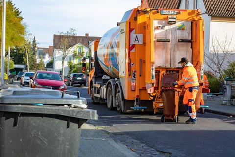 Müllmann des Städteservice schiebt am 03.11.2022 eine Biomülltonne zum Müllauto in der Ulmenstraße in Rüsselsheim. Foto: Volker Dziemballa (VF)
