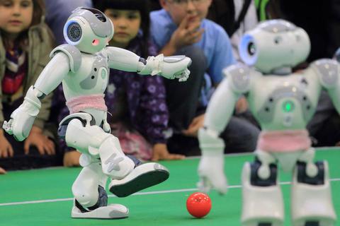 Zwei humanoide Roboter beim Fußballspielen. Symbolfoto: dpa 