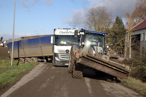 Mit einem Schlepper musste der Rübenlaster, der beim Abbiegen von einem Feldweg auf die Niersteiner Straße im Straßengraben gelandet war, befreit werden. Foto: Frank Möllenberg