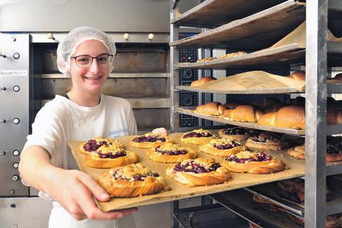 Die angehende Bäckerin, Caroline Welß, präsentiert frische Backware. Zum Sortiment gehören neben vollwertigen Broten auch süße Hefegebäcke. Foto: Thomas Schmidt