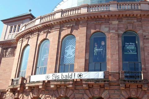 „Bis bald“, so vertröstet das Banner an der Fassade des Staatstheaters die Kulturfreunde. Foto: hbz/Jörg Henkel