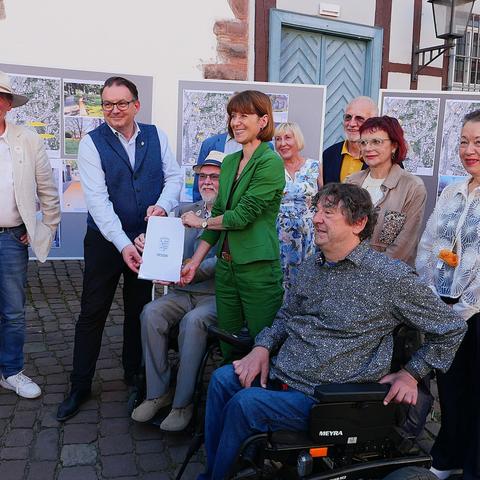 Michelstadts Bürgermeister Tobias Robischon und Ministerin Heike Hofmann präsentieren gemeinsam mit der Cittaslow-Projektgruppe "Barrierefreiheit" den Förderbescheid „Barrierefreie Innenstadt“ des Landes Hessen.