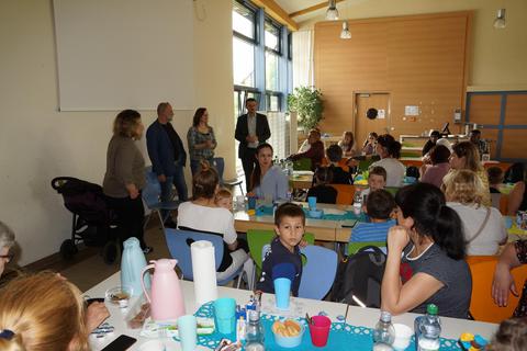 Sie informierten im „Elterncafè“: Eva Heldmann (von links stehend), Thomas Nickel, Dolmetscherin Alla Raupach und der stellvertretende Schulleiter Dennis Kroeschell. Foto: Thomas Raupach
