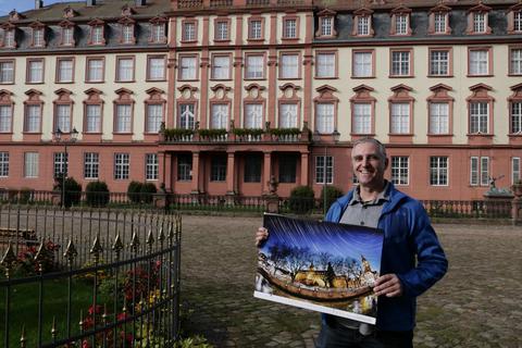 Jürgen Kiffe präsentiert seinen Odenwald-Kalender „Himmlische Aussichten 2023“ mit dem langzeitbelichteten Erbach-Motiv, das auf dem Marktplatz vor dem Schloss entstanden ist. © Manfred Giebenhain