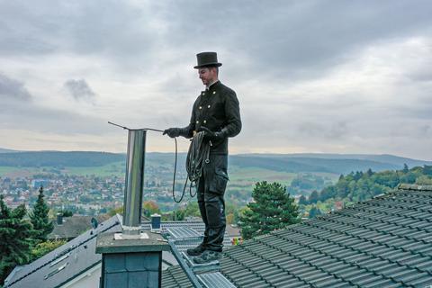 Auch der luftige Anteil gehört zur Arbeit des Schornsteinfegers weiter dazu (hier Maximilian Bachmann auf einem Dach hoch über der Stadt Erbach). Foto: Dirk Zengel