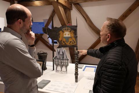 Museumsleiter Dr. Andreas Sattler (links) und Kulturamtsleiter Heinz Seitz nehmen die historische Marktfahne in Augenschein. Foto: Manfred Giebenhain