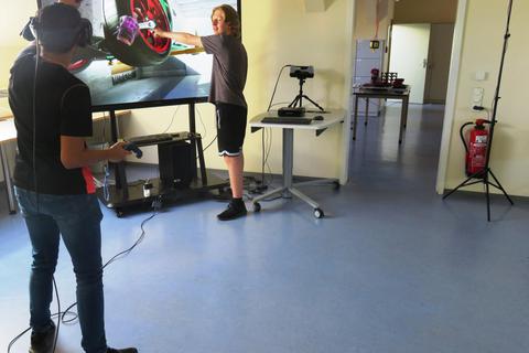 Die Schüler Mert Sahan (links) und Lukas Eckerhardt arbeiten mit einer VR-Simulation, um virtuell Wartungsarbeiten an einem Motor vorzunehmen. Foto: BSO