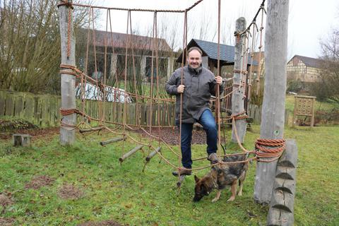Auch Ortsvorsteher Wolfgang Bersch steigt gern mal aufs Klettergerüst des großen Spielplatzes. Schäferhund Dana hat nichts dagegen. Foto: Kirsten Sundermann