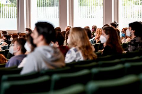 Studierende sitzen zu Beginn des Wintersemesters 2021/2022 in einem Hörsaal. Dabei tragen sie eine Mund-Nasen-Bedeckung. Foto: dpa