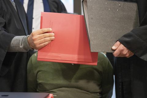 Mit Aktenmappen schirmen die Anwälte den Angeklagten Sven B. beim Prozessauftakt im Verhandlungssaal des Landgerichts in Frankfurt vor den Blicken der Kameras ab. Der 35-jährige Angeklagte soll als Fußball-Jugendtrainer in zahlreichen Fällen Jugendliche vergewaltigt und missbraucht haben.