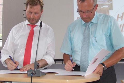 Schulleiter Martin Hinterlang (links) und Andreas Sandhäger setzen ihre Unterschriften unter den Kooperationsvertrag.  Foto: Kiehl