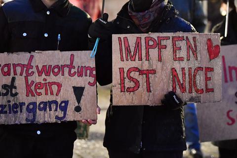 "Verantwortung ist kein Spaziergang", "Impfen ist Nice", und "Impfen statt schimpfen" steht auf Plakaten von Teilnehmern einer Kundgebung gegen die sogenannten "Spaziergänger". Symbolfoto: dpa