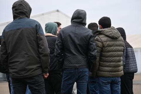 Männer stehen in einer Zeltstadt zusammen, die der Landkreis Bergstraße in Bensheim für Geflüchtete errichten ließ. „Die Problematik bezüglich der Unterbringung der Geflüchteten spitzt sich im Kreis Bergstraße, aber auch in zahlreichen anderen Regionen, von Woche zu Woche zu”, erklärt Landrat Christian Engelhardt.