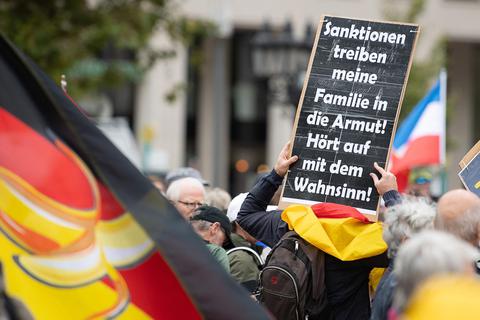 Vereint gegen Sanktionen: Querdenker und Russland-Unterstützer finden Gemeinsamkeiten bei einer Kundgebung in Frankfurt. Im Vordergrund eine Deutschlandfahne mit Banane, im Hintergrund die russische Fahne. Foto: dpa