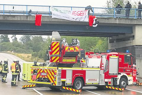 Mit einer Rettungsleiter "pflückte" die Feuerwehr die drei unter der Brücke baumelnden Aktivisten, die drei Stunden lang die A 5 lahmlegten.   Archivfoto: Berghöfer  