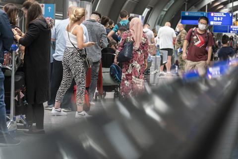 Passagiere warten in einer langen Schlange am Frankfurter Flughafen auf einen kostenlosen Corona-Test.  Frank Rumpenhorst/dpa 