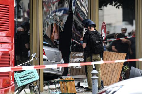 Nach der Amokfahrt von Berlin sichert die Polizei Spuren an dem zerbrochenen Schaufenster, in dem das Auto steckt. Foto: dpa/Fabian Sommer