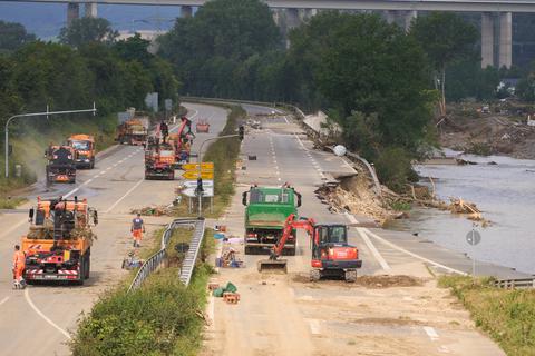Bautrupps versuchen, die Bundesstraße 266 bei Bad Neuenahr wieder befahrbar zu machen. Das Hochwasser hat die Strecke unterspült.  Foto: dpa/ Thomas Frey