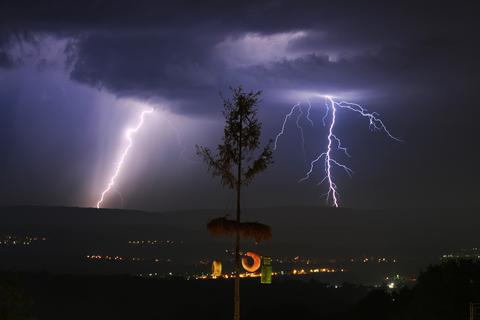 Blitze schlagen im Taunus ein. Im Vordergrund der Kerbebaum in Wackernheim (Kreis Mainz-Bingen).  Archivfoto: Julian Stratenschulte/dpa