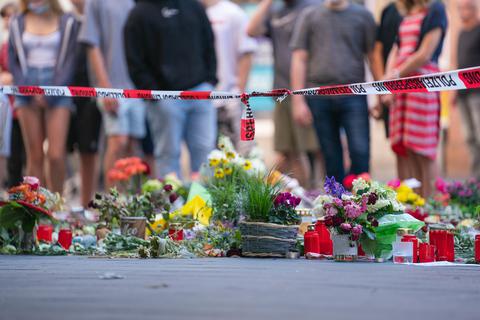 Trauerkerzen und Blumen liegen vor einem Kaufhaus in der Würzburger Innenstadt, in dem ein Mann Menschen mit einem Messer attackiert hatte. Foto: dpa