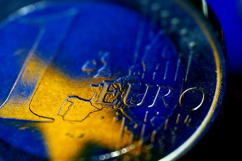 Die Fahne der Europäischen Union spiegelt sich am in einer Euro-Münze. Foto: Oliver Berg/dp
