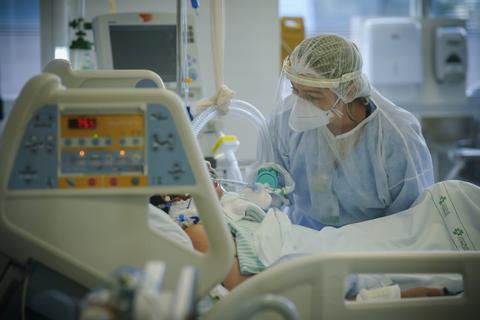 Ein medizinische Mitarbeiterin behandelt im Krankenhaus einen Covid-19-Patienten auf der Intensivstation. Foto: dpa