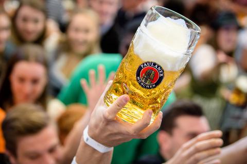 ARCHIV - 21.09.2019, Bayern, München: Auftakt zum Oktoberfest. Besucher greifen im Paulaner-Festzelt nach ihrem ersten Bierkrug. (Zu dpa «OB Reiter gibt Entscheidung über diesjährige Wiesn bekannt ») Foto: Matthias Balk/dpa +++ dpa-Bildfunk +++