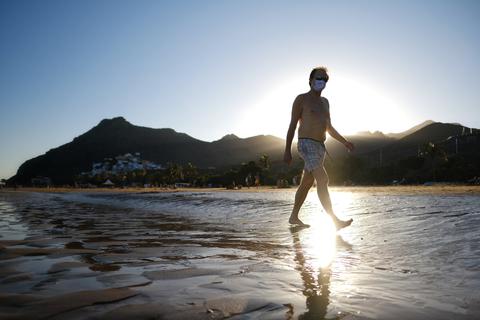  Ein Mann mit Mundschutz geht am Strand, als die Bundesregierung die Kanaren wegen steigender Infektionszahlen als Risikogebiet einstuft. Foto: Andres Gutierrez