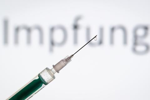 ARCHIV - 11.05.2019, Nordrhein-Westfalen, Bielefeld: ILLUSTRATION - Eine Spritze wird vor den Schriftzug «Impfung» gehalten. Das Mainzer Biopharma-Unternehmen Biontech und der US-Konzern Pfizer haben mit Großbritannien eine erste Liefervereinbarung zu einem möglichen, gerade in der Entwicklung befindlichen Corona-Impfstoff geschlossen. Foto: Friso Gentsch/dpa +++ dpa-Bildfunk +++