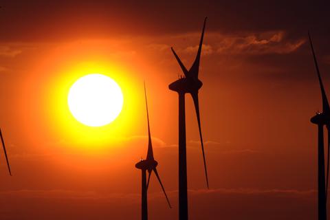 Windräder drehen sich vor einer untergehenden Sonne.  Archivfoto: dpa