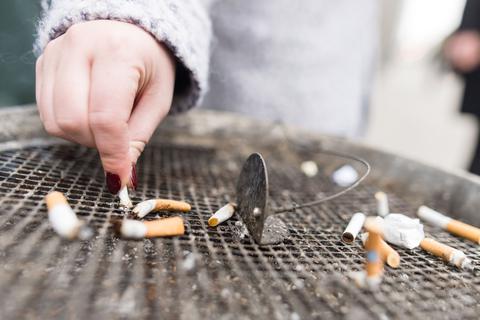 Zigarette wird auf Aschenbecherrost ausgedrückt