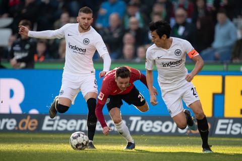 Hannovers Nicolai Müller spielt gegen Frankfurts Ante Rebic (links) und Frankfurts Makoto Hasebe. Foto: dpa