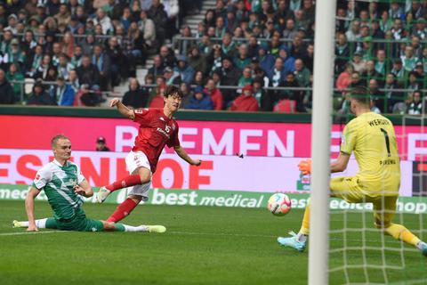 15.10.2022, Bremen: Fußball: Bundesliga, Werder Bremen - FSV Mainz 05, 10. Spieltag, wohninvest Weserstadion. Werder Amos Pieper (l) und Torwart Jiri Pavlenka (r) können das 0:2 durch den Mainzer Jae-Sung Lee nicht verhindern. Foto: Carmen Jaspersen/dpa - WICHTIGER HINWEIS: Gemäß den Vorgaben der DFL Deutsche Fußball Liga bzw. des DFB Deutscher Fußball-Bund ist es untersagt, in dem Stadion und/oder vom Spiel angefertigte Fotoaufnahmen in Form von Sequenzbildern und/oder videoähnlichen Fotostrecken zu verwerten bzw. verwerten zu lassen. +++ dpa-Bildfunk +++