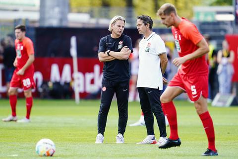 Kaiserslauterns Trainer Dirk Schuster (rechts) und Kaiserslauterns Co-Trainer Sascha Franz stehen beim Aufwärmtraining auf dem Spielfeld.  Foto: dpa