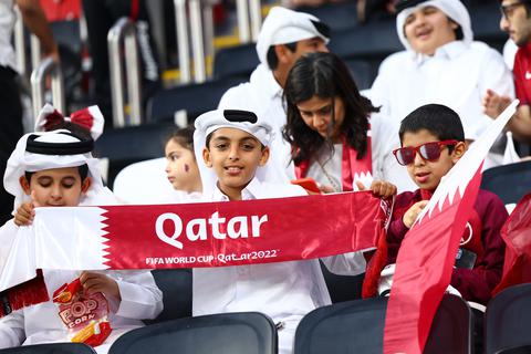 Ein Fan aus Katar hält vor dem Spiel ein Fanschal in Händen. 