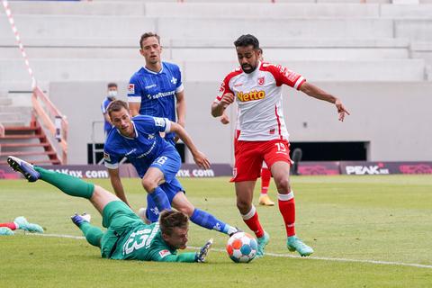 Sarpreet Singh (Jahn Regensburg) setzt sich gegen Matthias Bader (SV Darmstadt 98) und Torwart Marten Behrens (SV Darmstadt 98) durch und erzielt das Tor zum 0:1. Foto: dpa