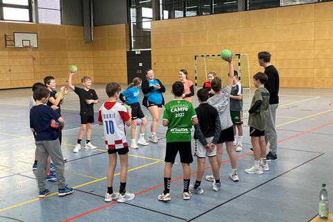 Die Handball-Klasse von Lehrertrainer Volker Michel (r.) im Kreis vor dem Aufwärmtraining.
