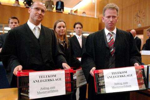 Kisten mit Klageschriften tragen die Anwälte Peter Kühn und Ralf Plück (rechts) im Jahr 2005 in das Landgericht Frankfurt. Archivfoto: dpa