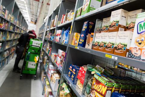 : Ein Mitarbeiter des Lebensmittellieferdienstes Amazon Fresh packt im Depot von Amazon fresh die bestellten Waren in eine Transporttasche. Der Online-Handel mit Lebensmitteln boomt. Foto: dpa
