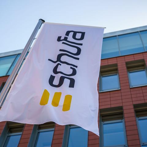 Eine Flagge mit dem Firmenlogo flattert vor dem Geschäftssitz der Schufa in Wiesbaden. (zu dpa: „Schufa speichert historische Daten von Verbrauchern“)