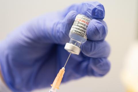 Ein Mitarbeiter zieht im Impfzentrum Mainz eine Spritze mit dem an die Omikron-BA.1-Variante angepassten Impfstoff Comirnaty von Biontech und Pfizer auf.  